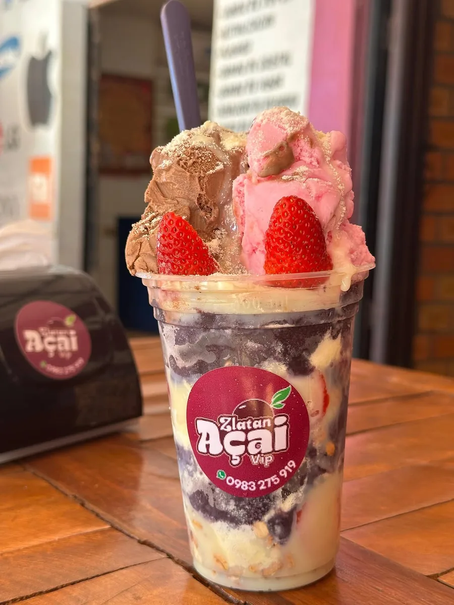 Vaso de açaí Zlatan con helado y frutillas sobre la mesa del local